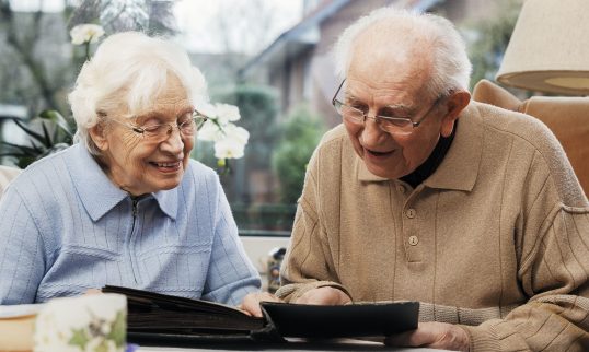 Senior couple watching old photographs at home